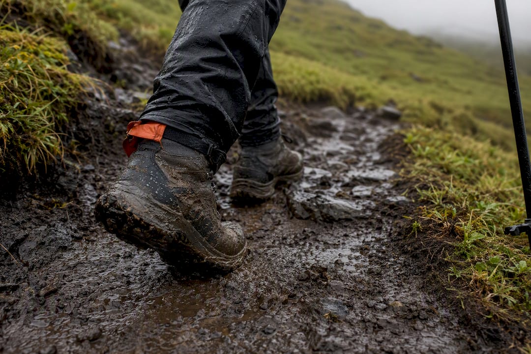 Boots crossing muddy uphill hot spring trail