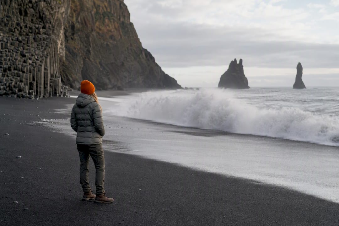 Visitor watching waves from Reynisfjara beach