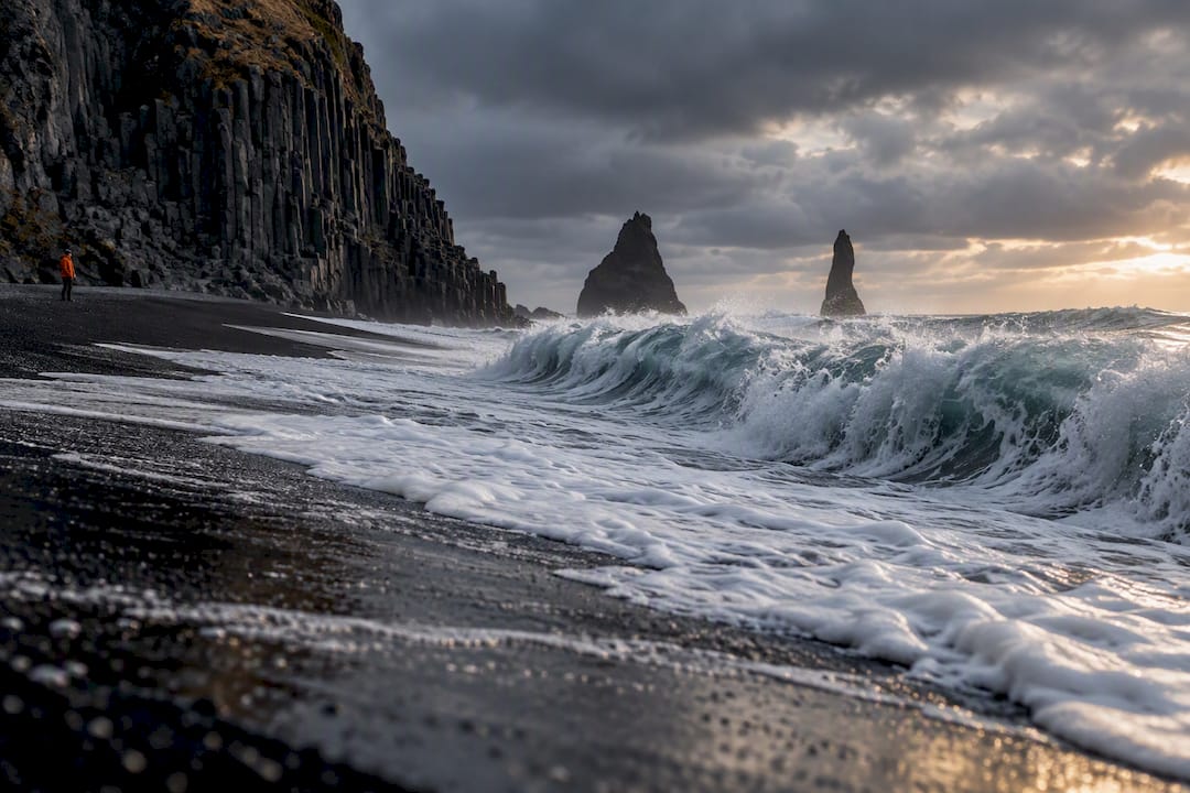 Sneaker wave surging across Reynisfjara black sand