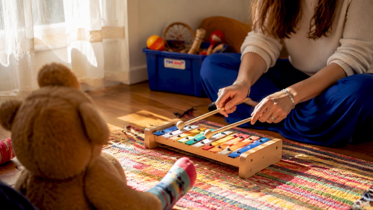 Music therapist tuning xylophone for child session