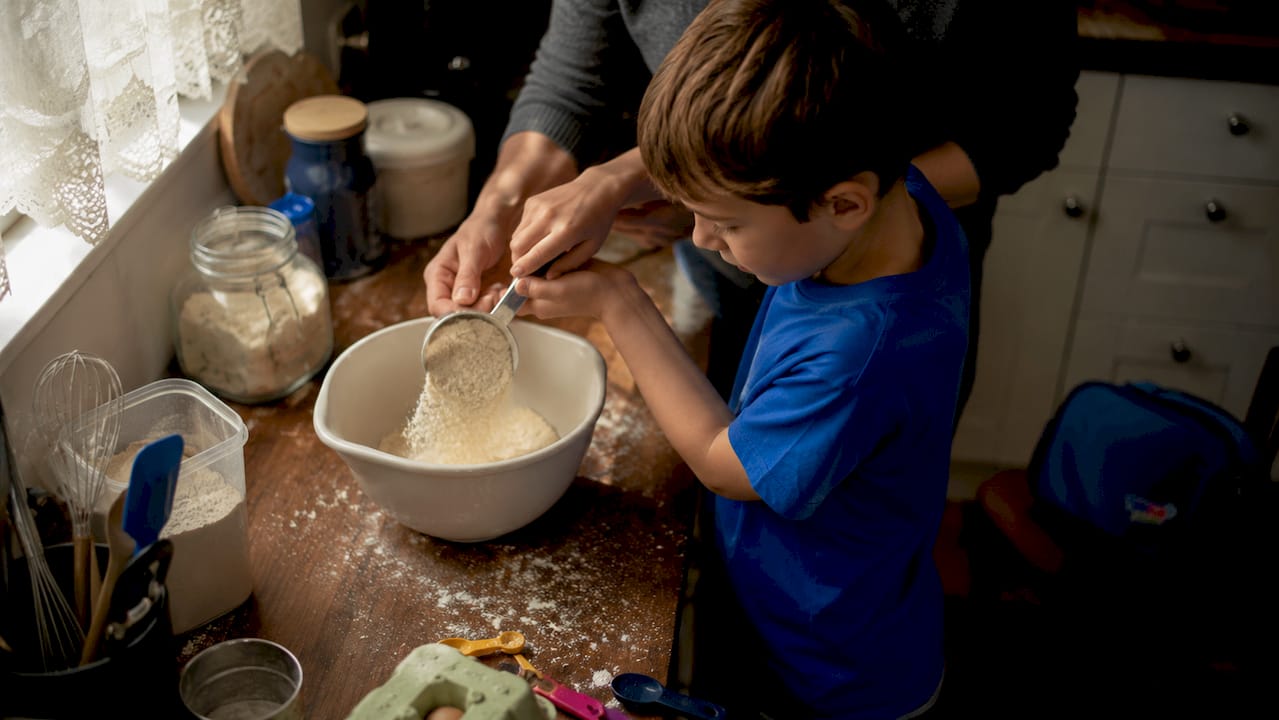 Child cooking supervised by adult