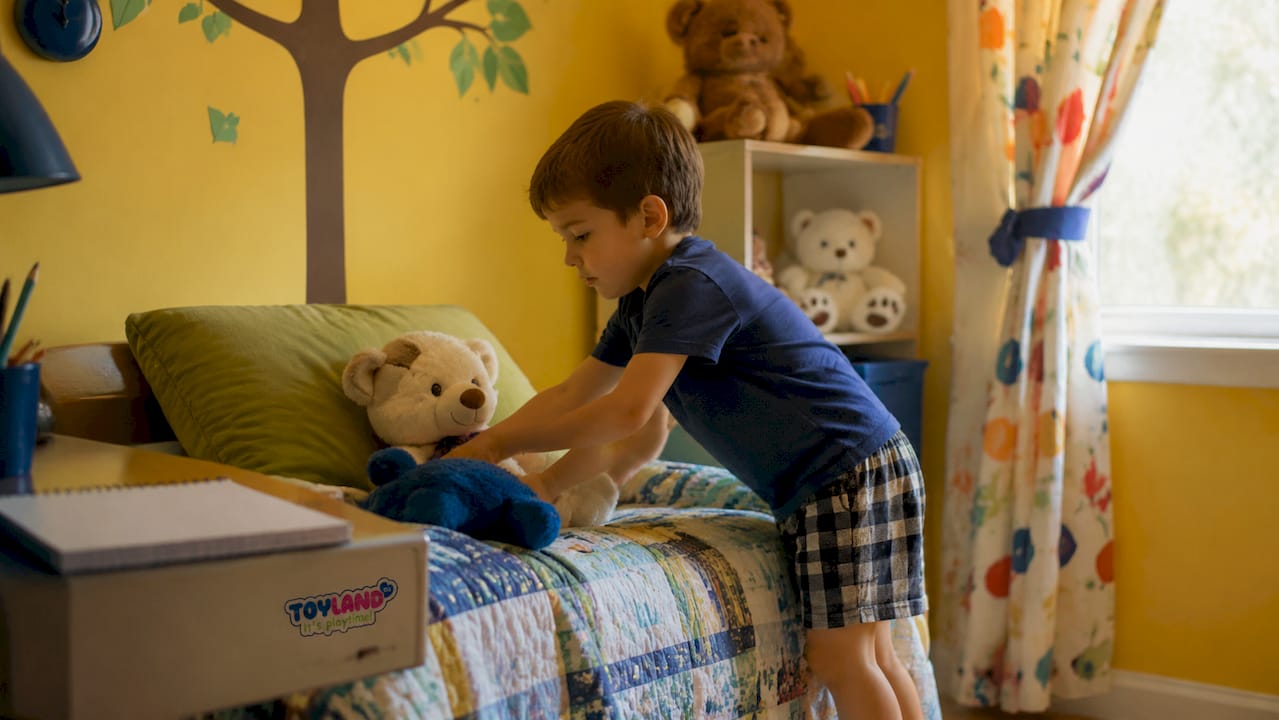 6-year-old boy making bed in bedroom