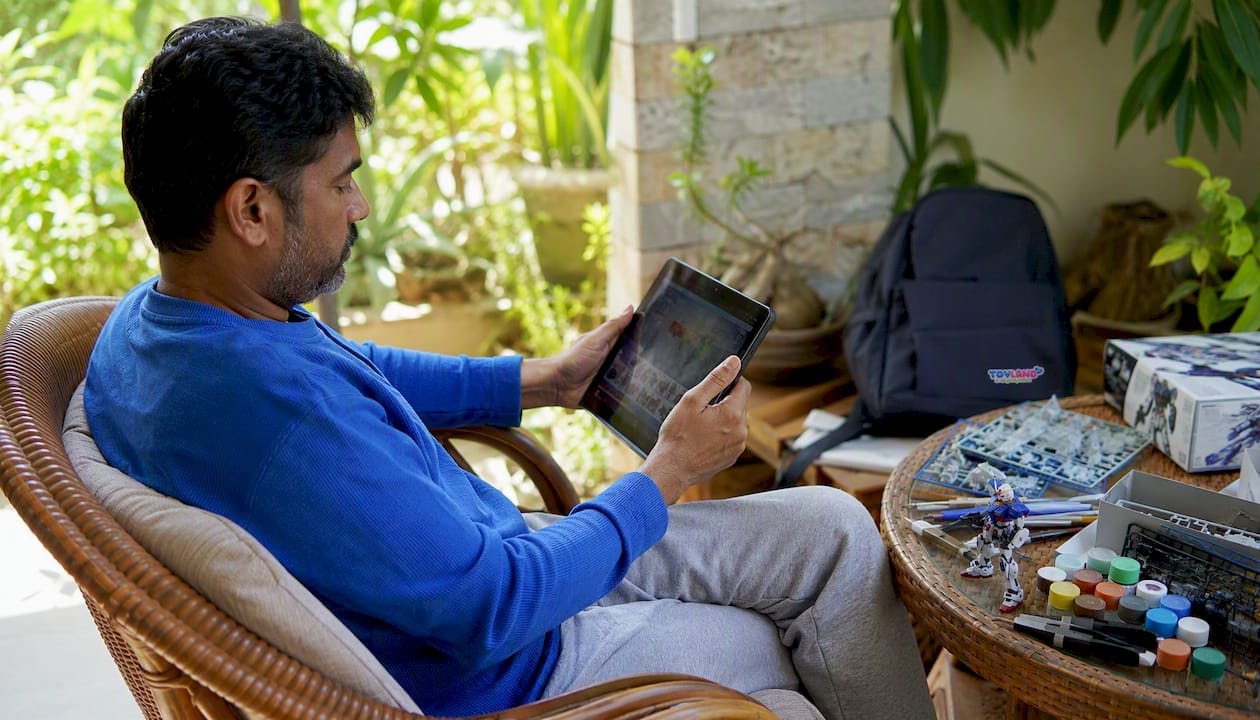 Man browsing toy and hobby catalogs on tablet