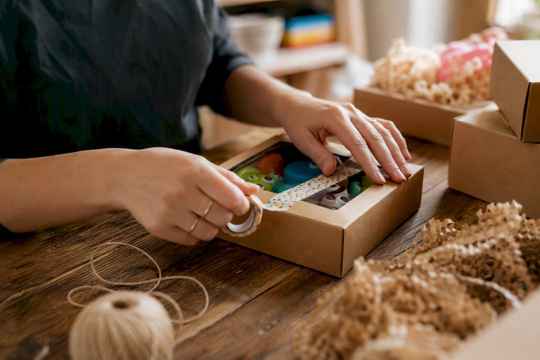 Hands sealing a generic package for shipping