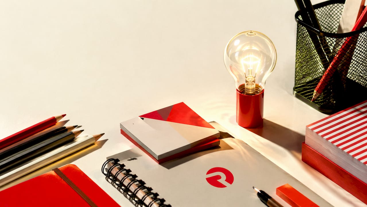 Flat-lay of office supplies with glowing lightbulb motif