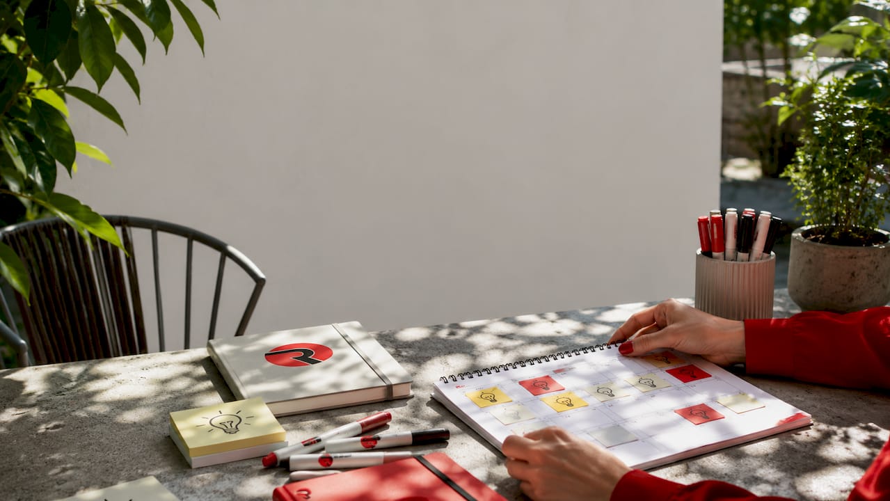 Overhead hands arranging content calendar with brand colors