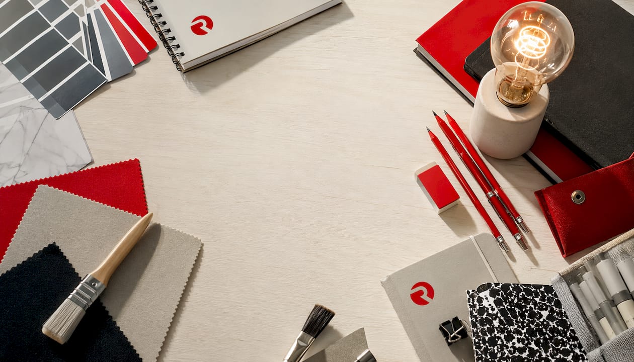 Flat-lay of creative tools with glowing lightbulb and brand colors