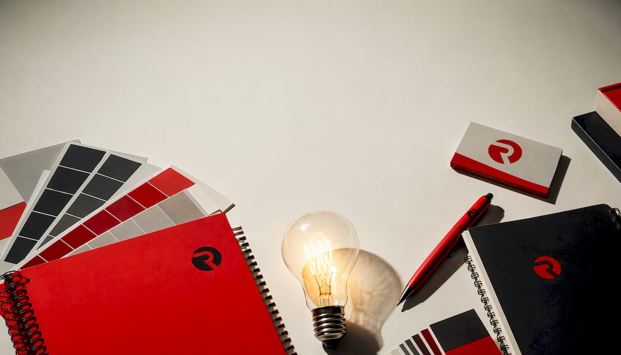 Flat-lay of branded creative office supplies with glowing lightbulb
