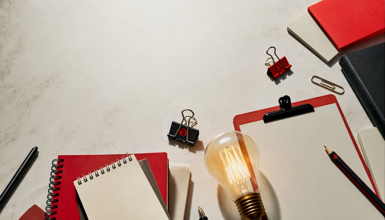 Creative supplies flat-lay with glowing bulb and sketches