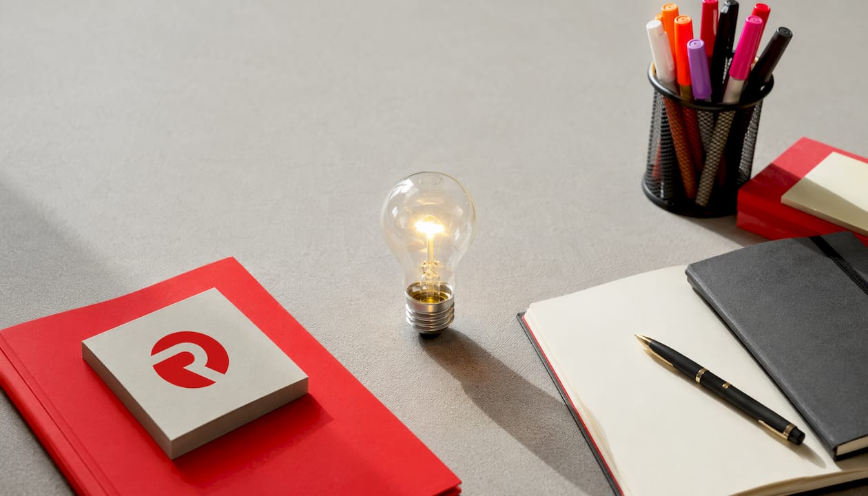 Flat-lay of product innovation process tools with glowing bulb