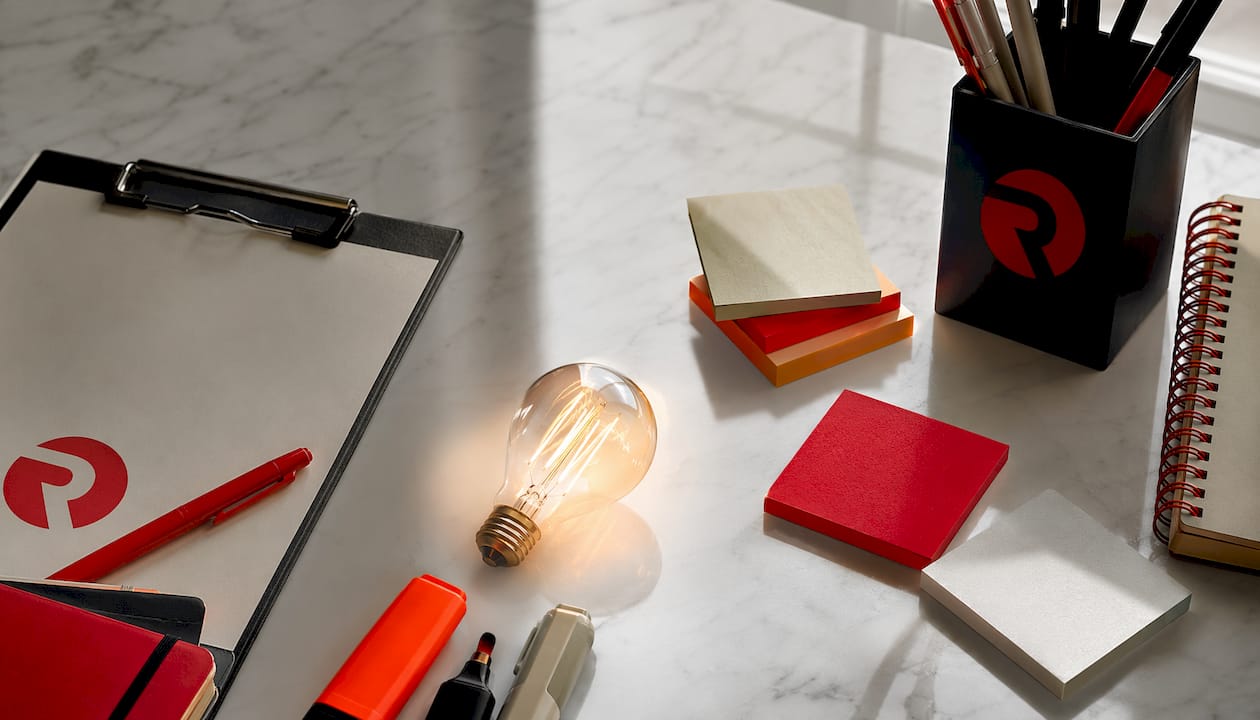 Close-up flat-lay of creative supplies and glowing lightbulb