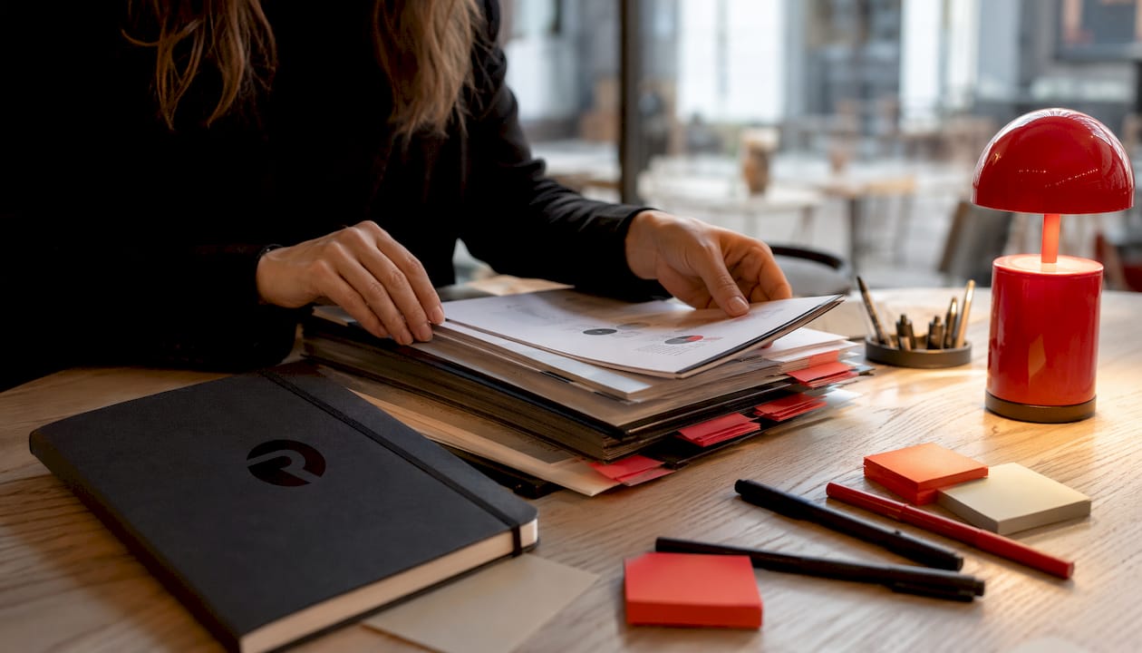 Hands sorting competitor analysis folders on desk