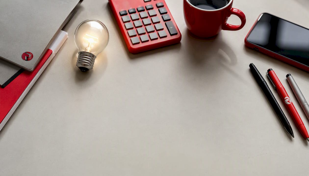 Marketing workspace flatlay with glowing lightbulb and brand colours