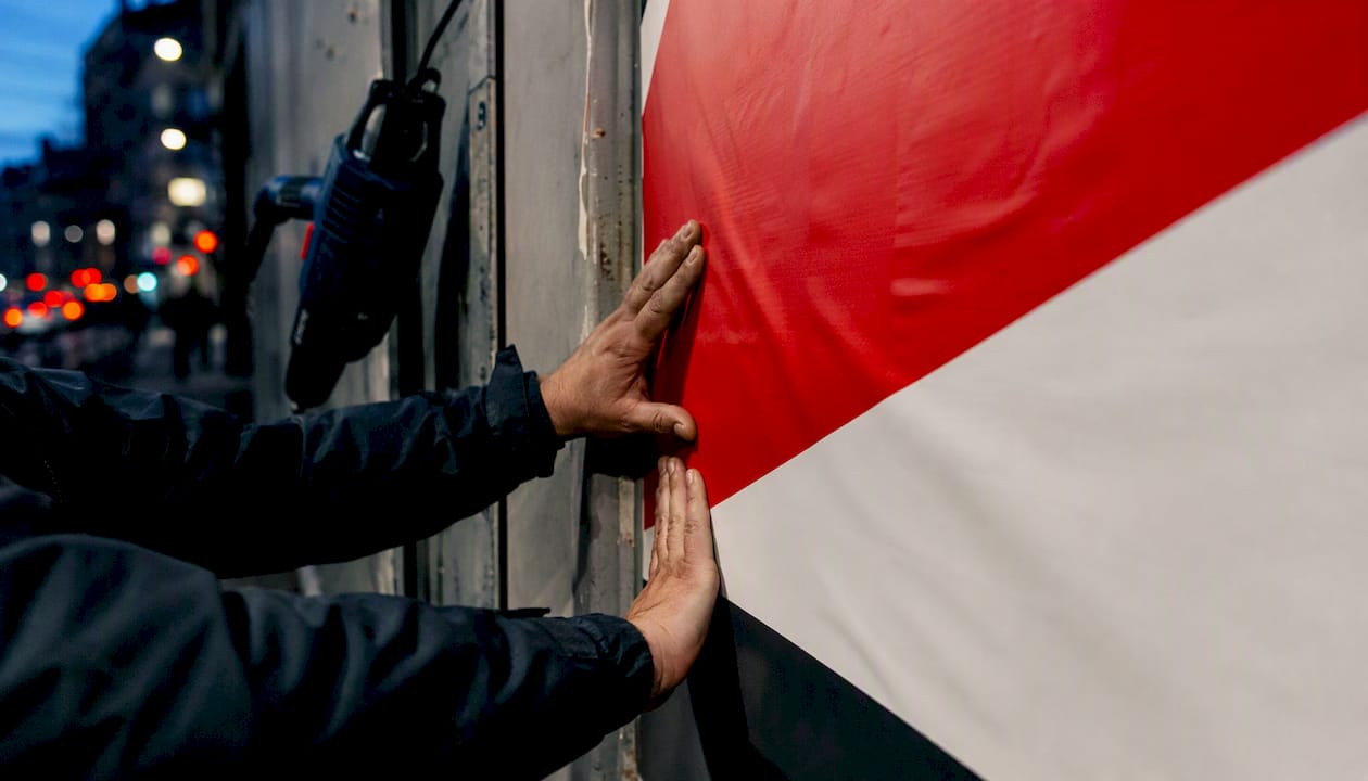 Close-up of hands installing billboard vinyl