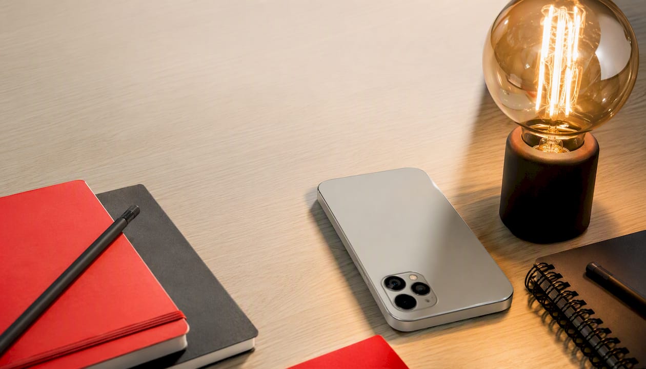 Smartphone on creative branded desk with glowing bulb