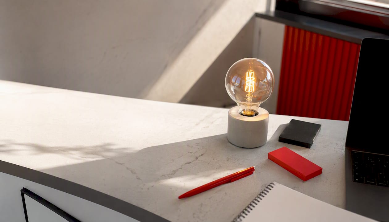 Flat-lay of branded desk with glowing bulb and tools