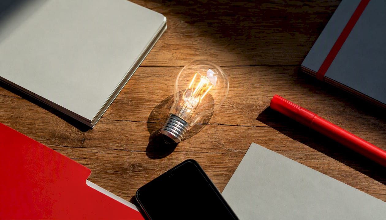 Creative workspace with glowing bulb and supplies