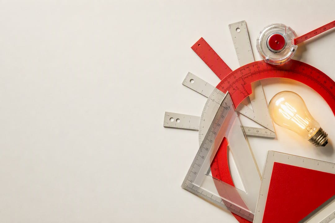 Geometric layout tools and glowing bulb flat-lay