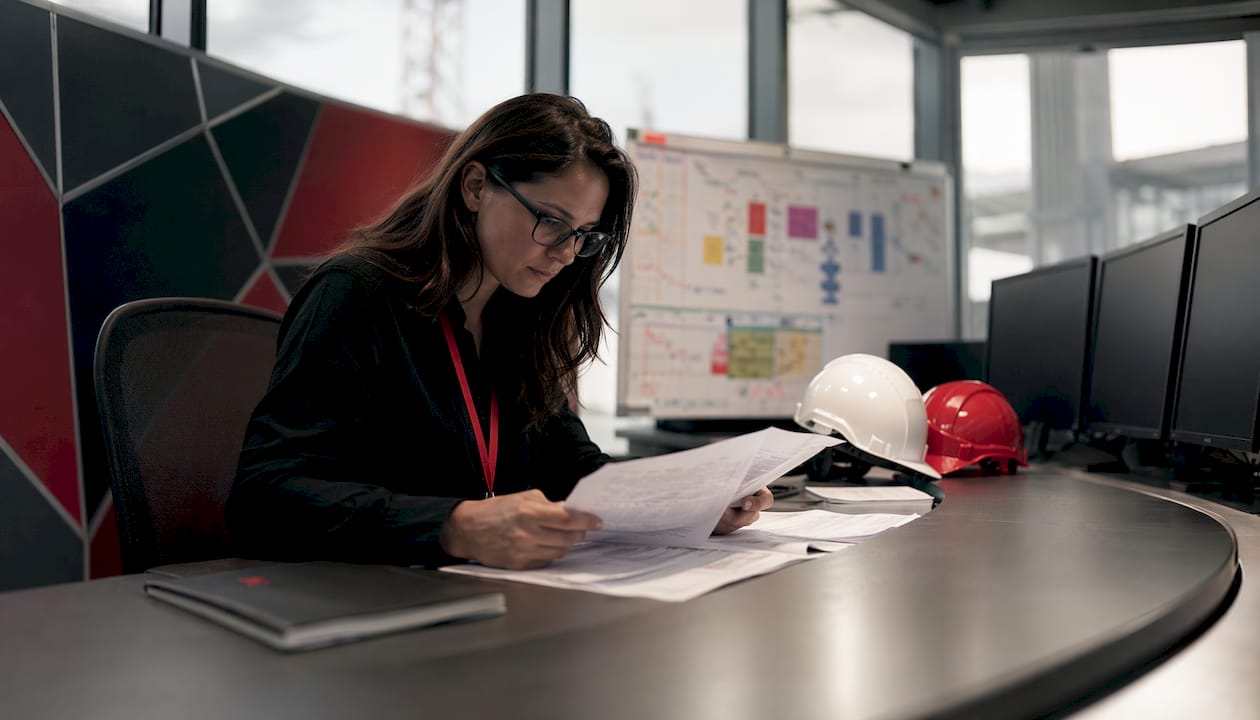 Safety analyst reviewing risk reports indoors