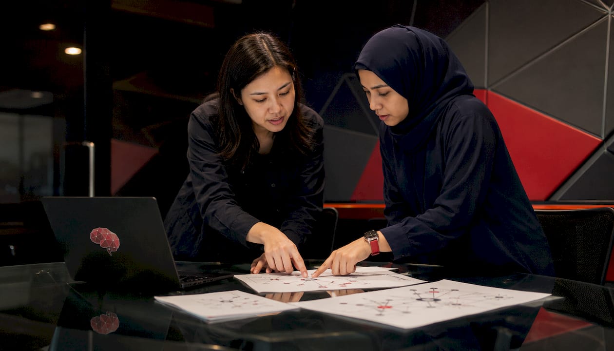 Two IT specialists collaborating over telemetry diagrams