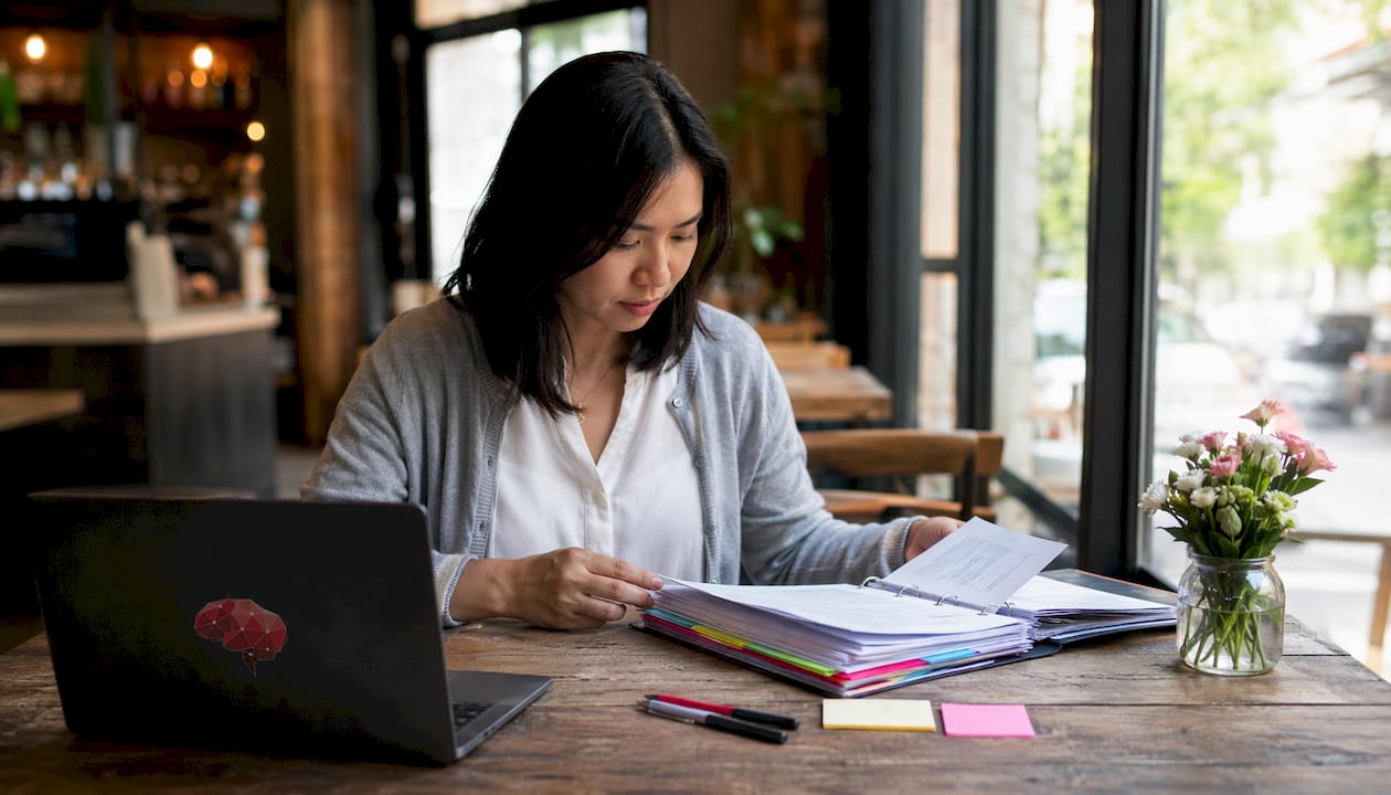 Woman organizing runbook documentation at desk