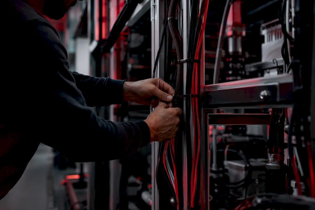 Technician connecting network cable in infrastructure room