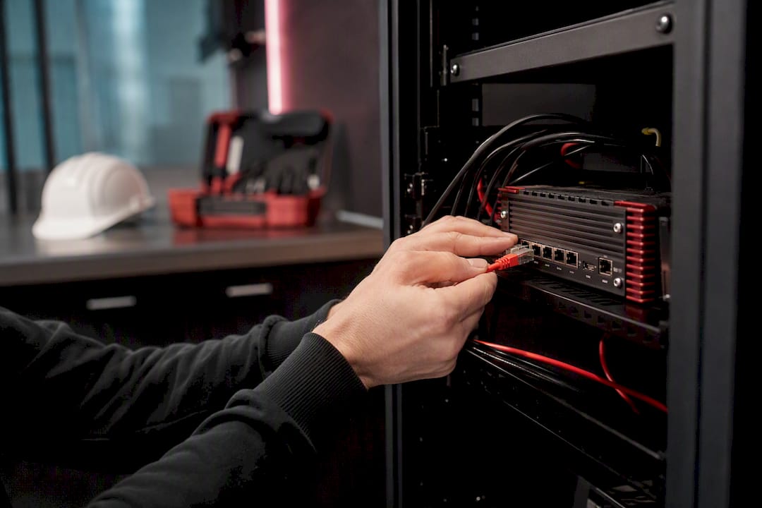 Hands securing network cable in control room