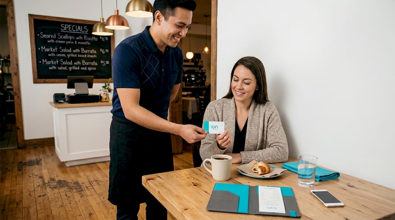 Server gives loyalty card to guest