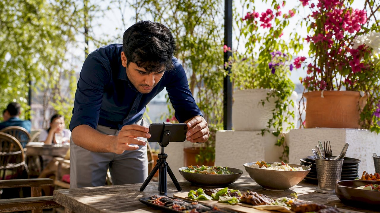 Man filming catering dishes for social media
