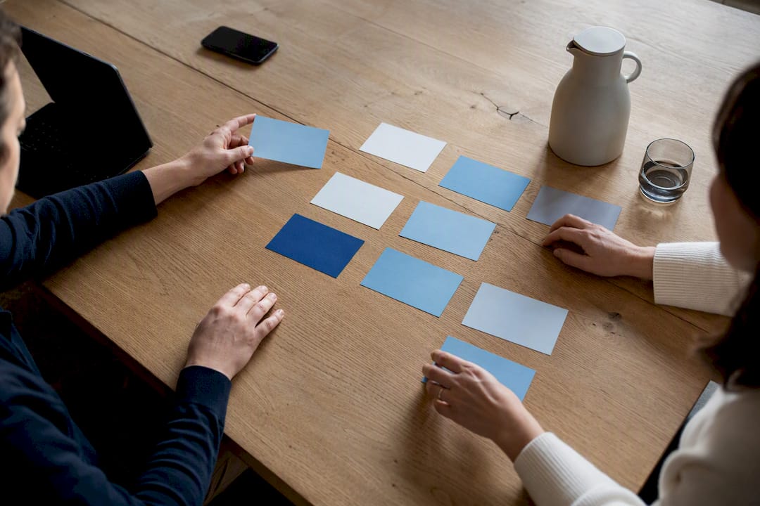 Handen die taakkaarten voor PR-beheer organiseren