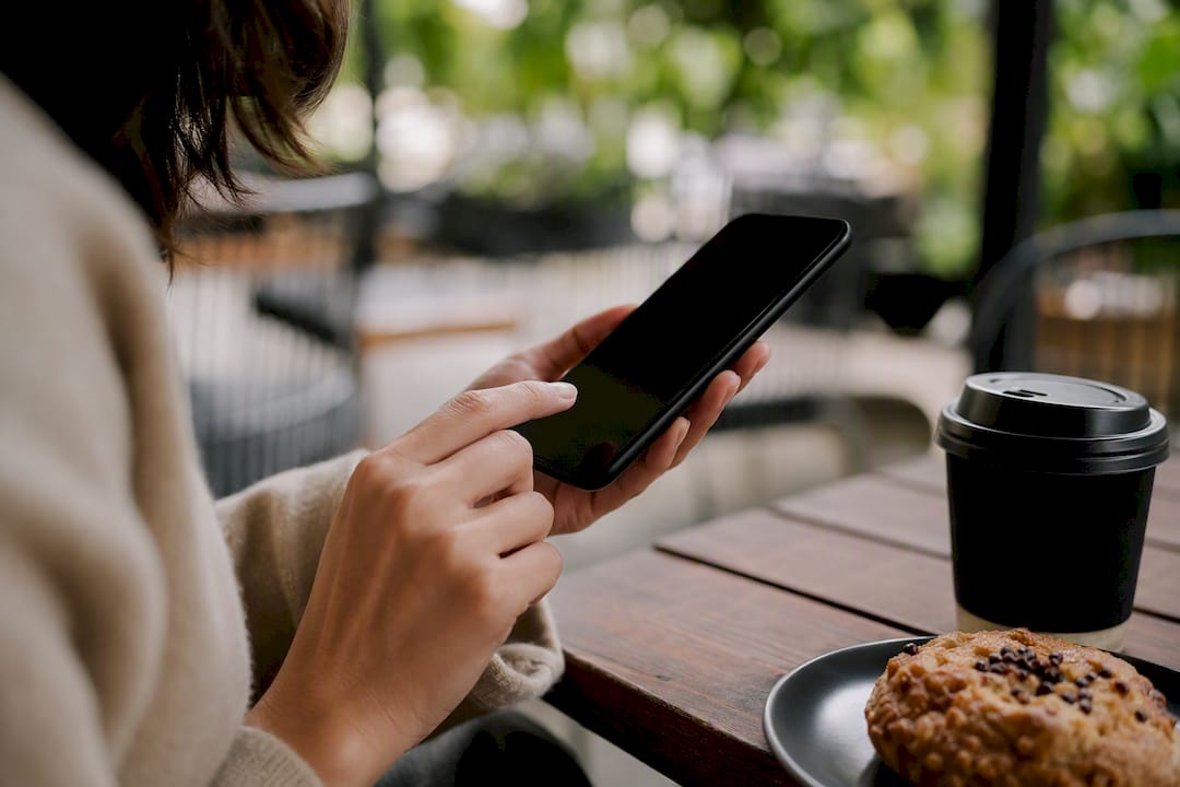 Hand die een smartphone vasthoudt, klaar om gegevens in te voeren