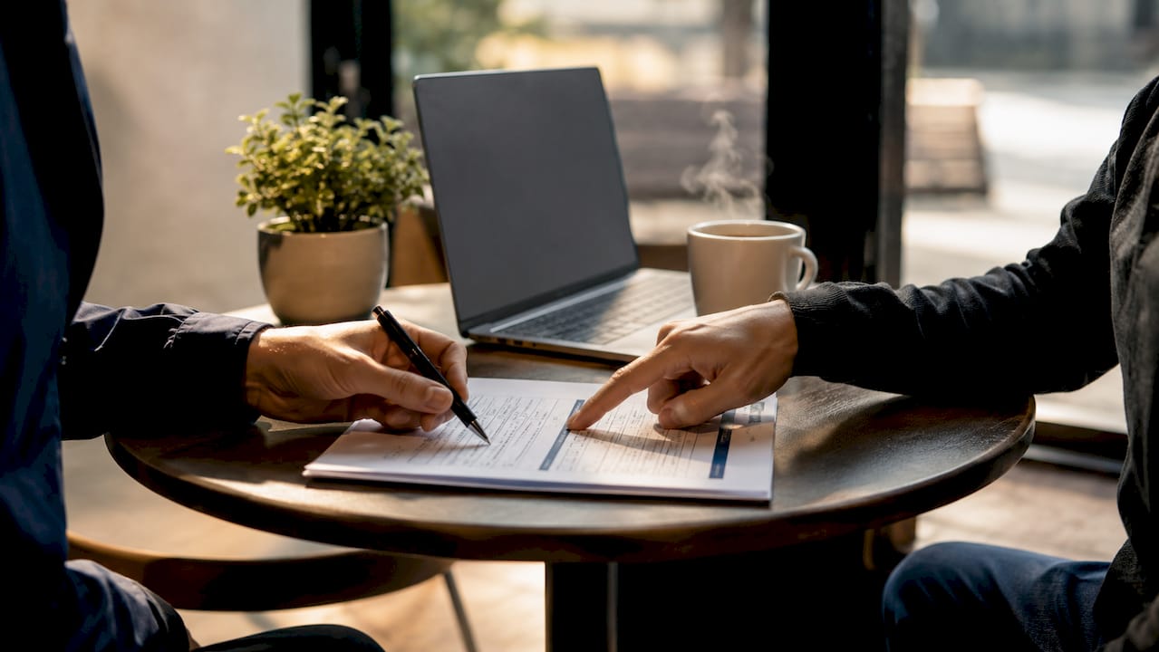 Hands marking international payment checklist