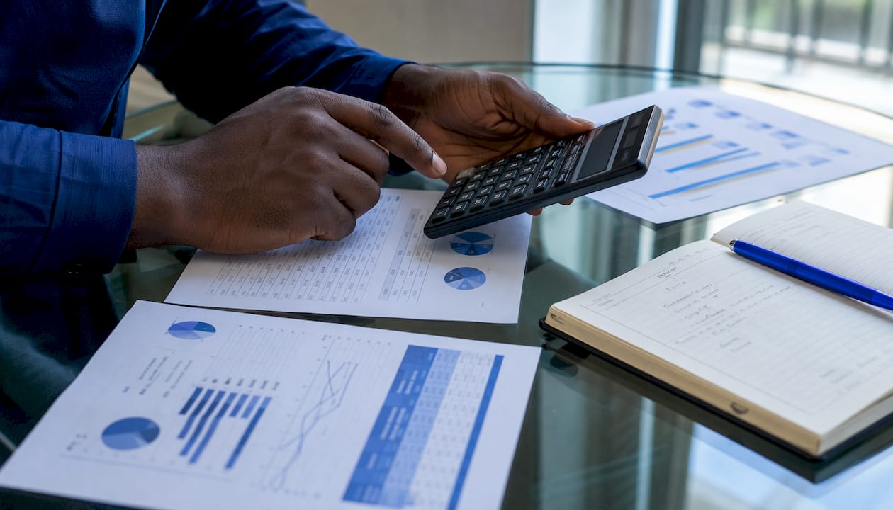 Hands calculating currency conversion fees