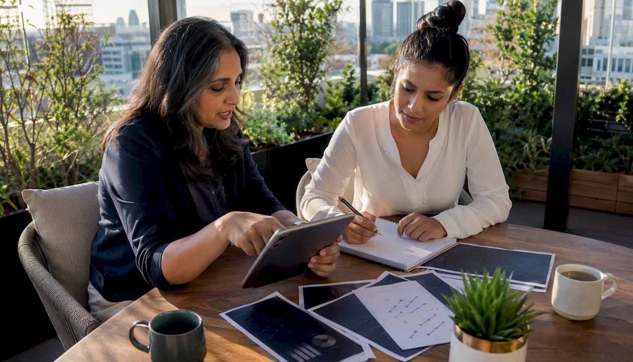 Two women discussing fintech commission plans