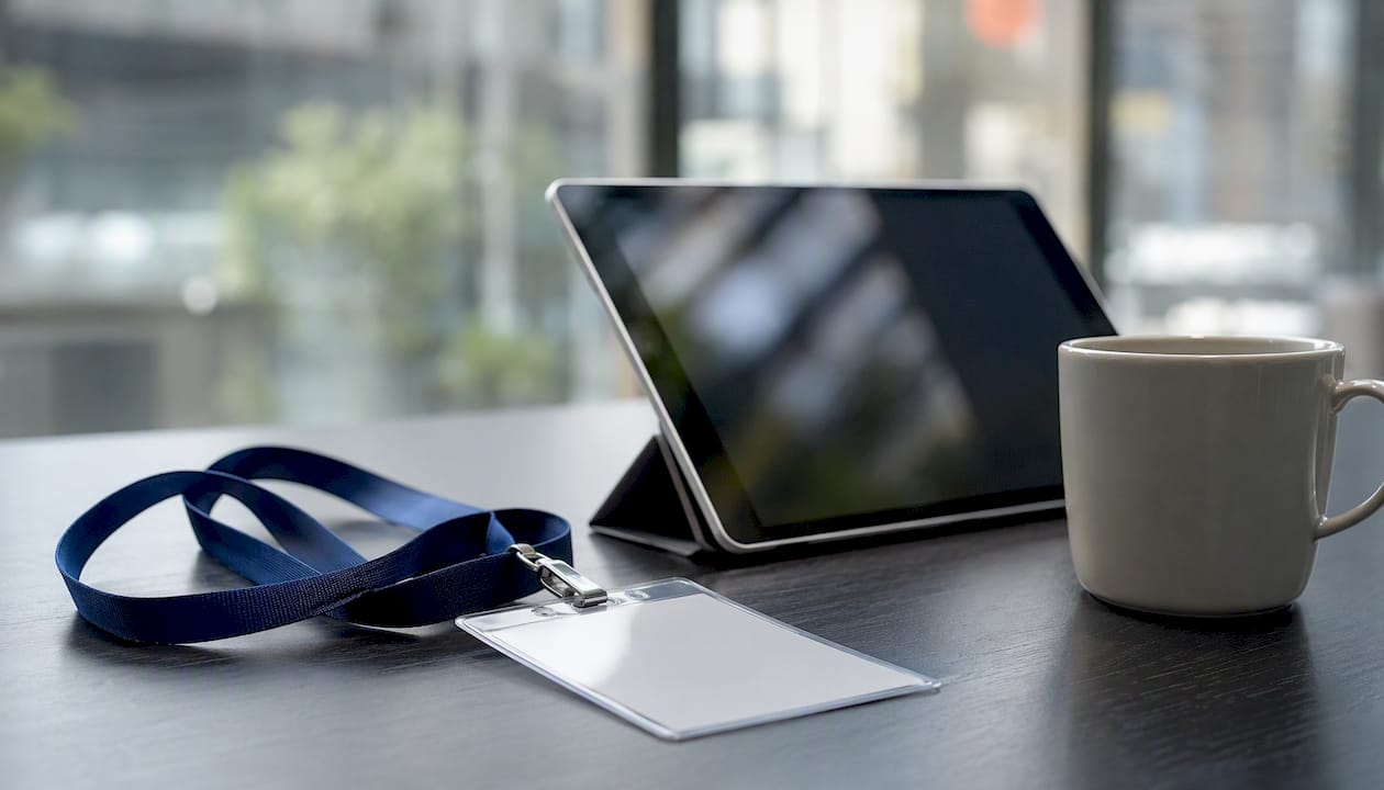 Conference badge and tablet on desk