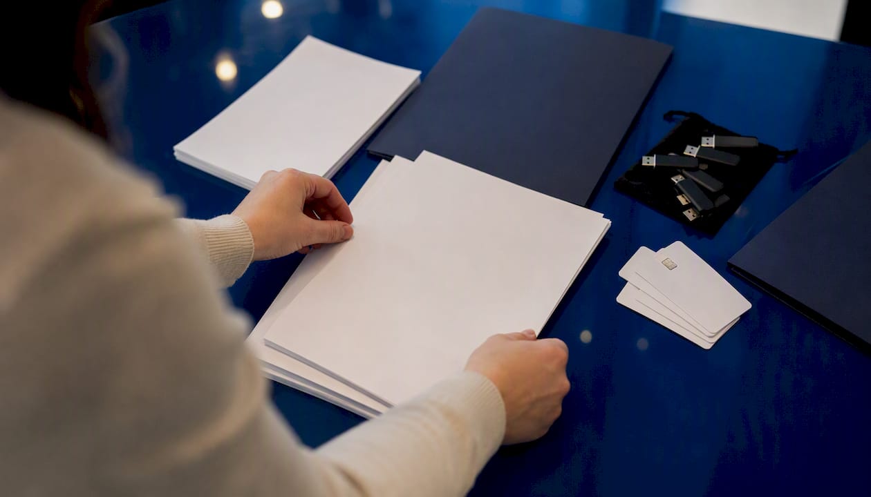 Hands arranging onboarding materials