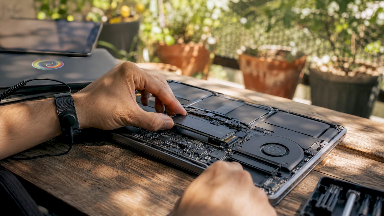 Close-up van handen die een SSD in een pc-behuizing plaatsen