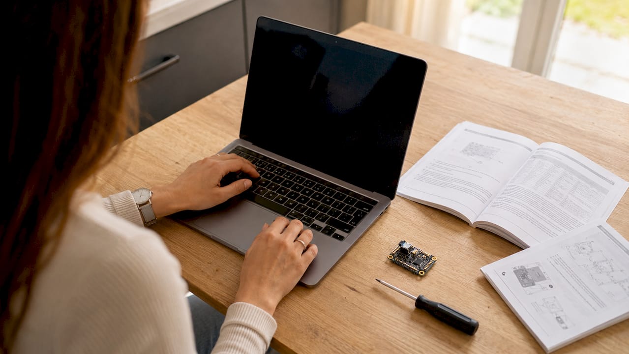 Iemand werkt op een laptop met behulp van technische hulpmiddelen.