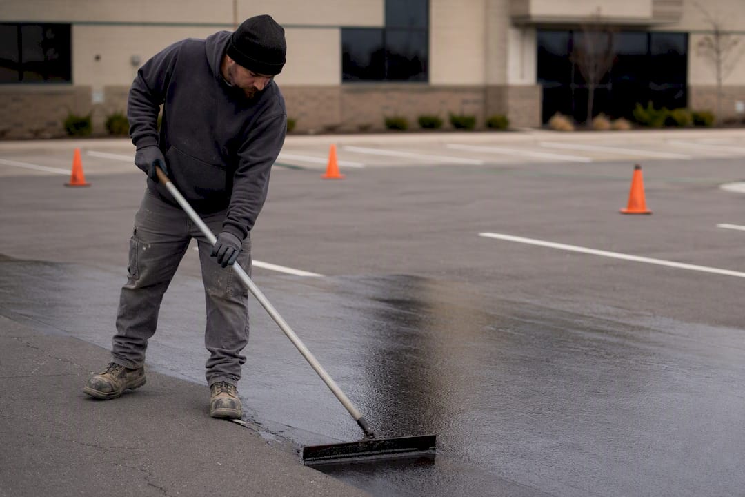 Brush applying sealcoat to asphalt surface
