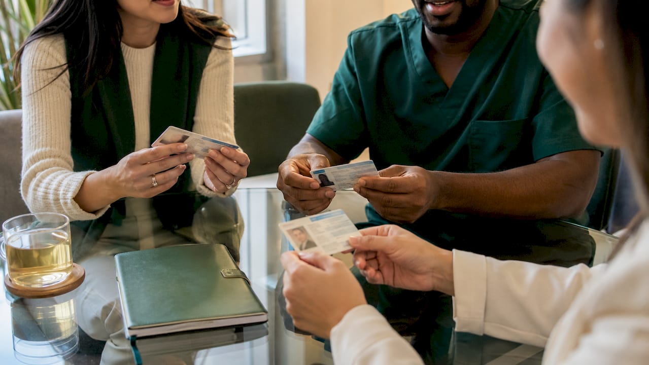Hands holding healthcare license cards