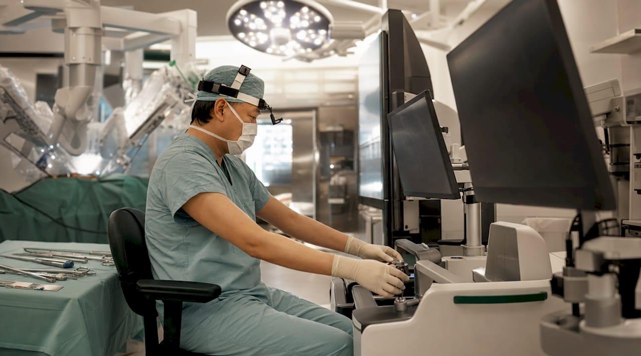 Surgeon preparing robotic surgical equipment in operating room