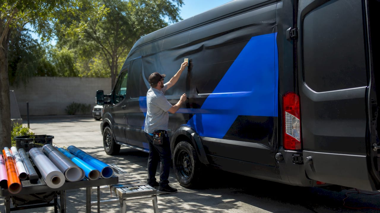 Installer applying premium vinyl wraps on van