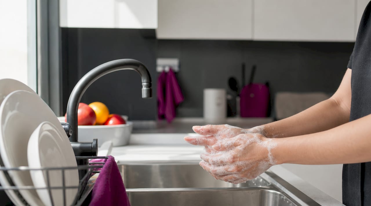 Hands washing with gentle cleanser under lukewarm water