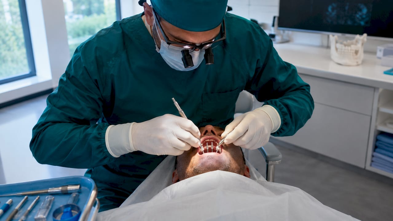 Dental surgeon placing All-on-4 implants in clinic