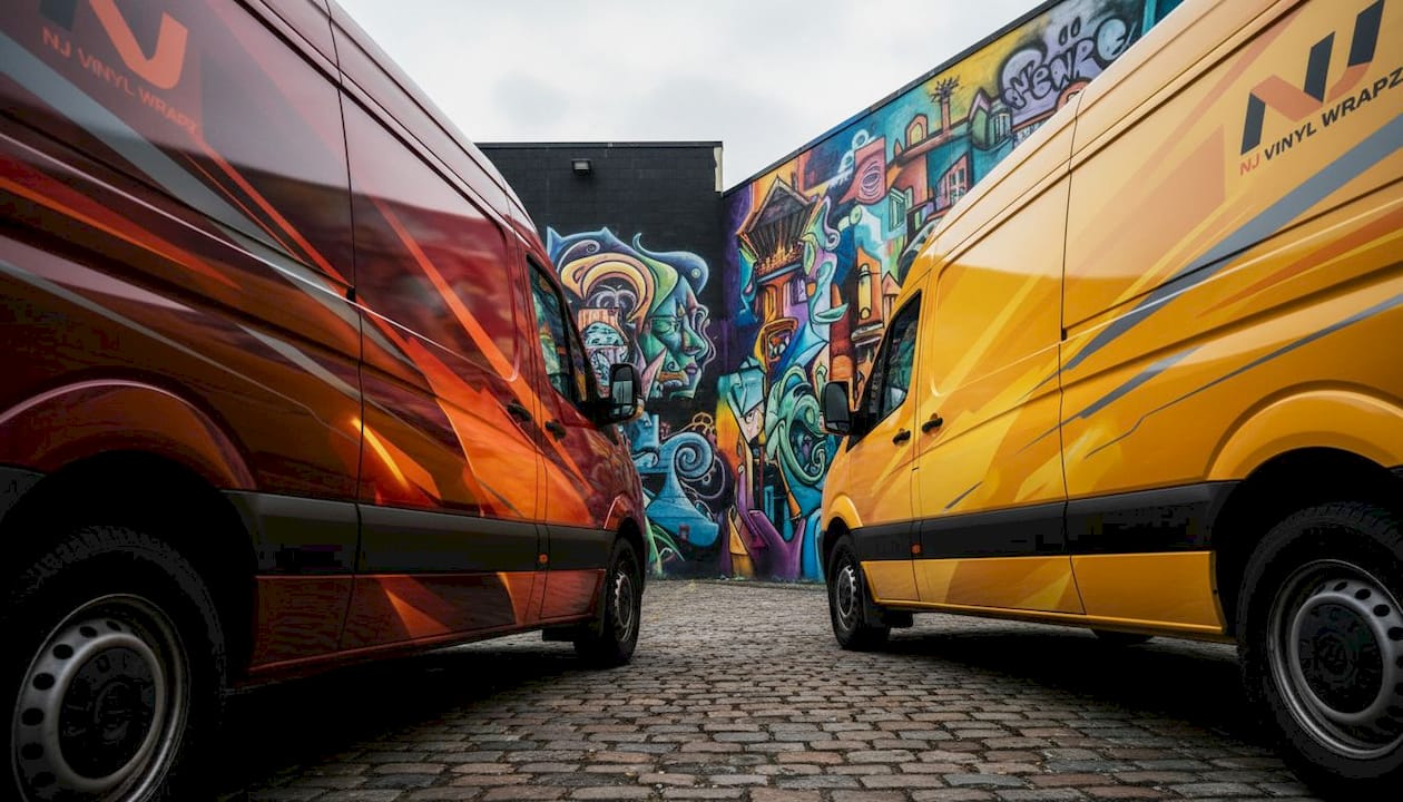 Food delivery vans with red yellow orange wraps outdoors
