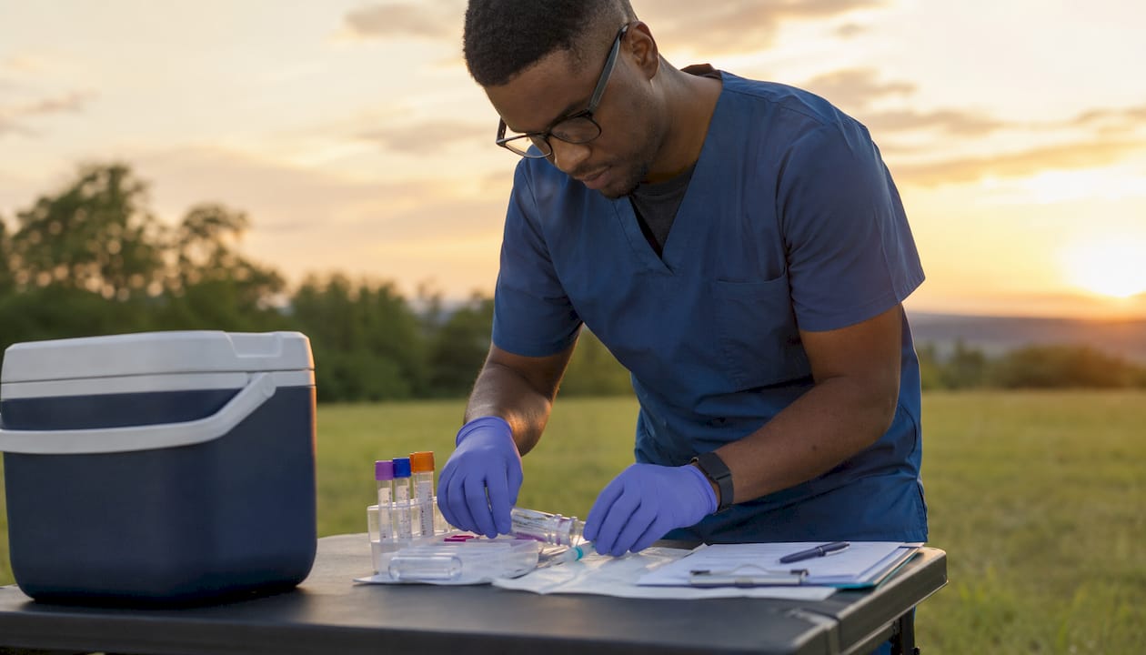 Phlebotomist preparing blood sample kit in lab