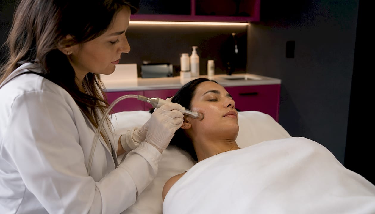Microdermabrasion device buffing client's face