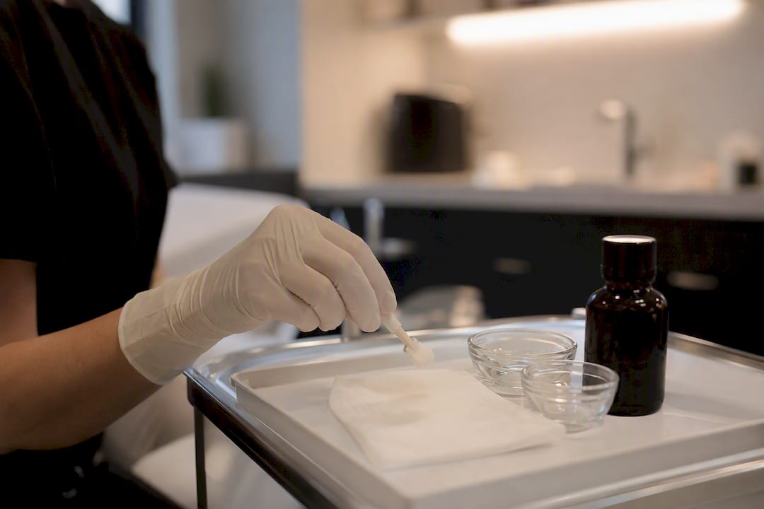 Gloved hand preparing medium peel applicator