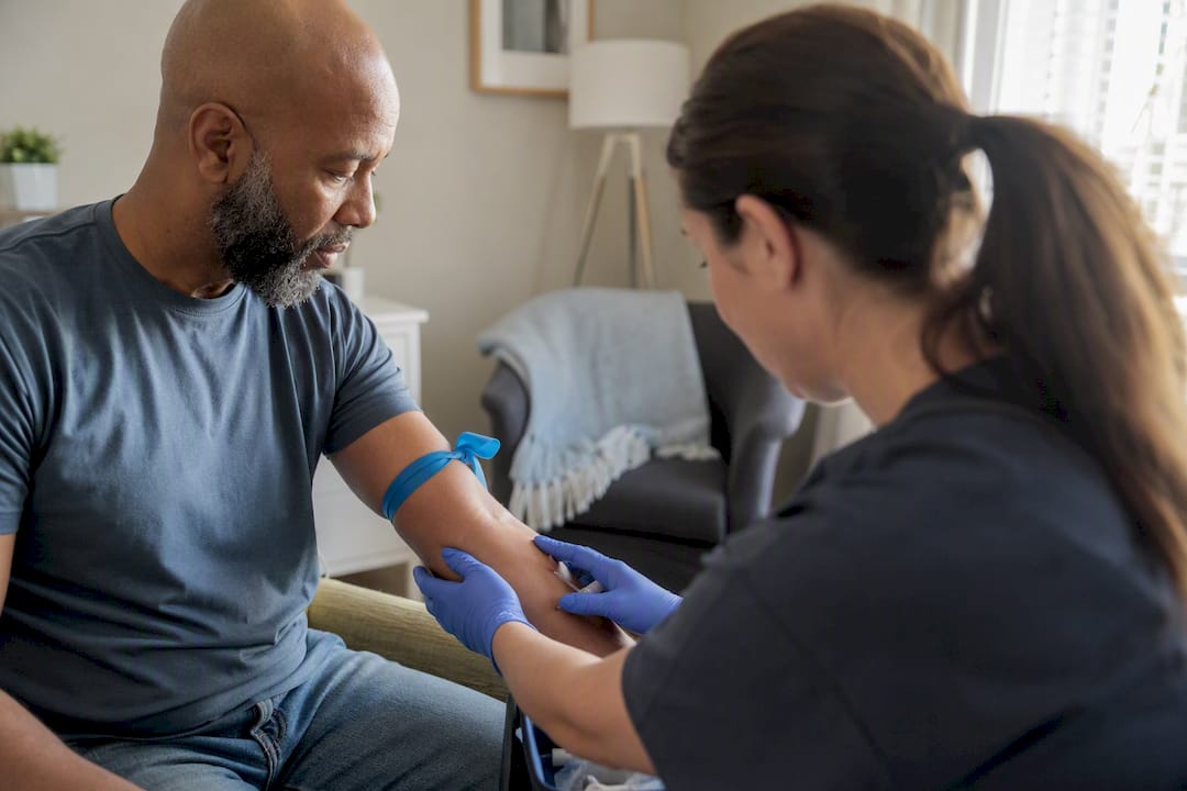 Phlebotomist positioning patient arm for mobile blood draw