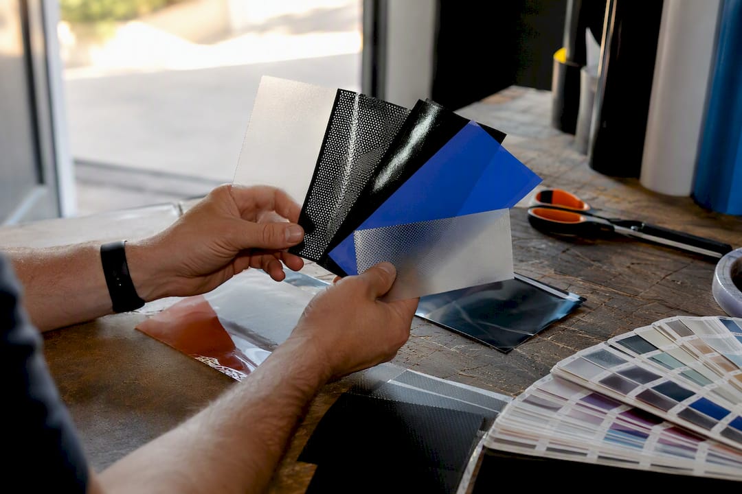 Hand displaying window graphic material samples